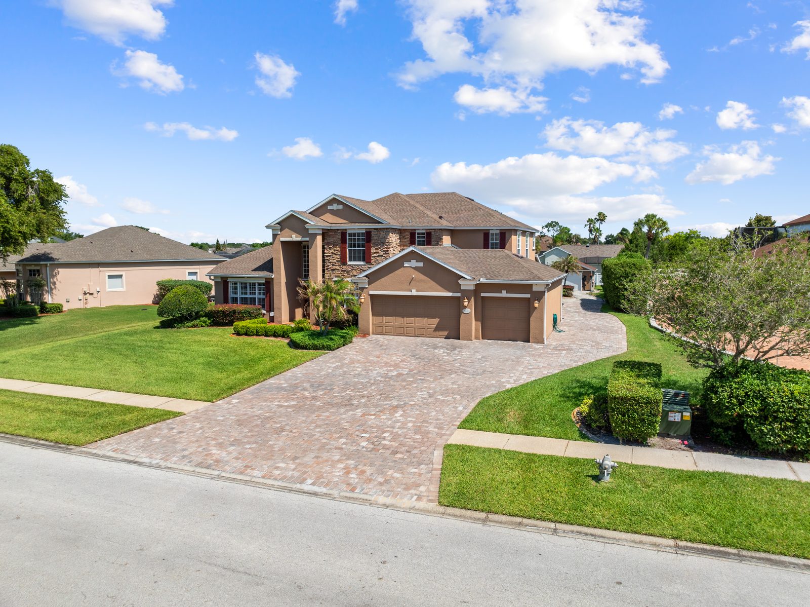 Front elevation with three-car garage and paver driveway